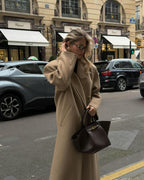 Woman in a camel coat carrying the brown Manhattan Tote on a city street