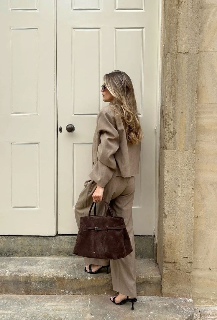 Sienna deep brown belted suede top handle bag styled with a neutral tailored suit