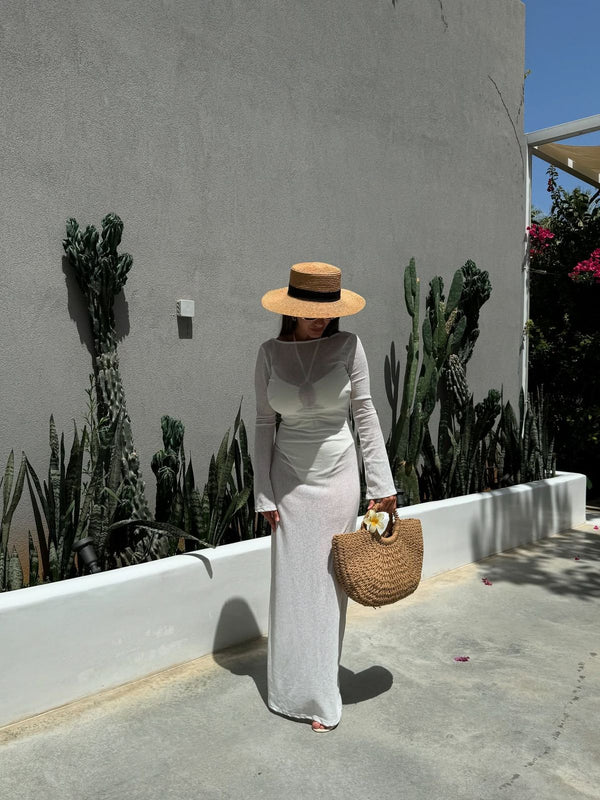 woman in white dress carrying natural crescent straw bag