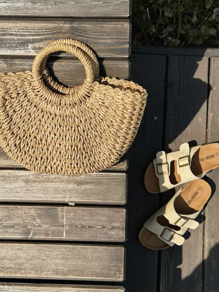 natural tan crescent straw bag flat lay with sandals