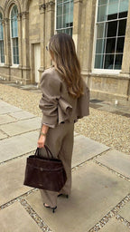 1. Sienna belted suede top handle bag in deep brown styled with a neutral women’s suit