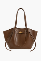 A brown leather tote bag with double shoulder straps and a gold-tone front clasp, photographed against a clean off-white background.