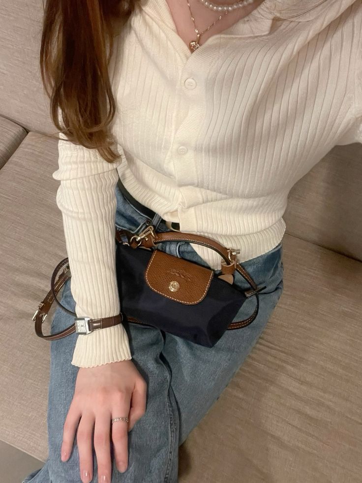Le Pliage Mini Pouch in Navy worn crossbody with a cream cardigan