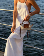 Le Pliage Mini Pouch in Paper beige carried by hand at the waterfront