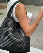 woman carrying oversized black woven tote bag on shoulder street style - black - tote bag