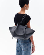 women wearing oversized black knotted tote bag shoulder street style