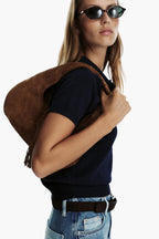 women carrying caramel fringe hobo bag shoulder full length street style