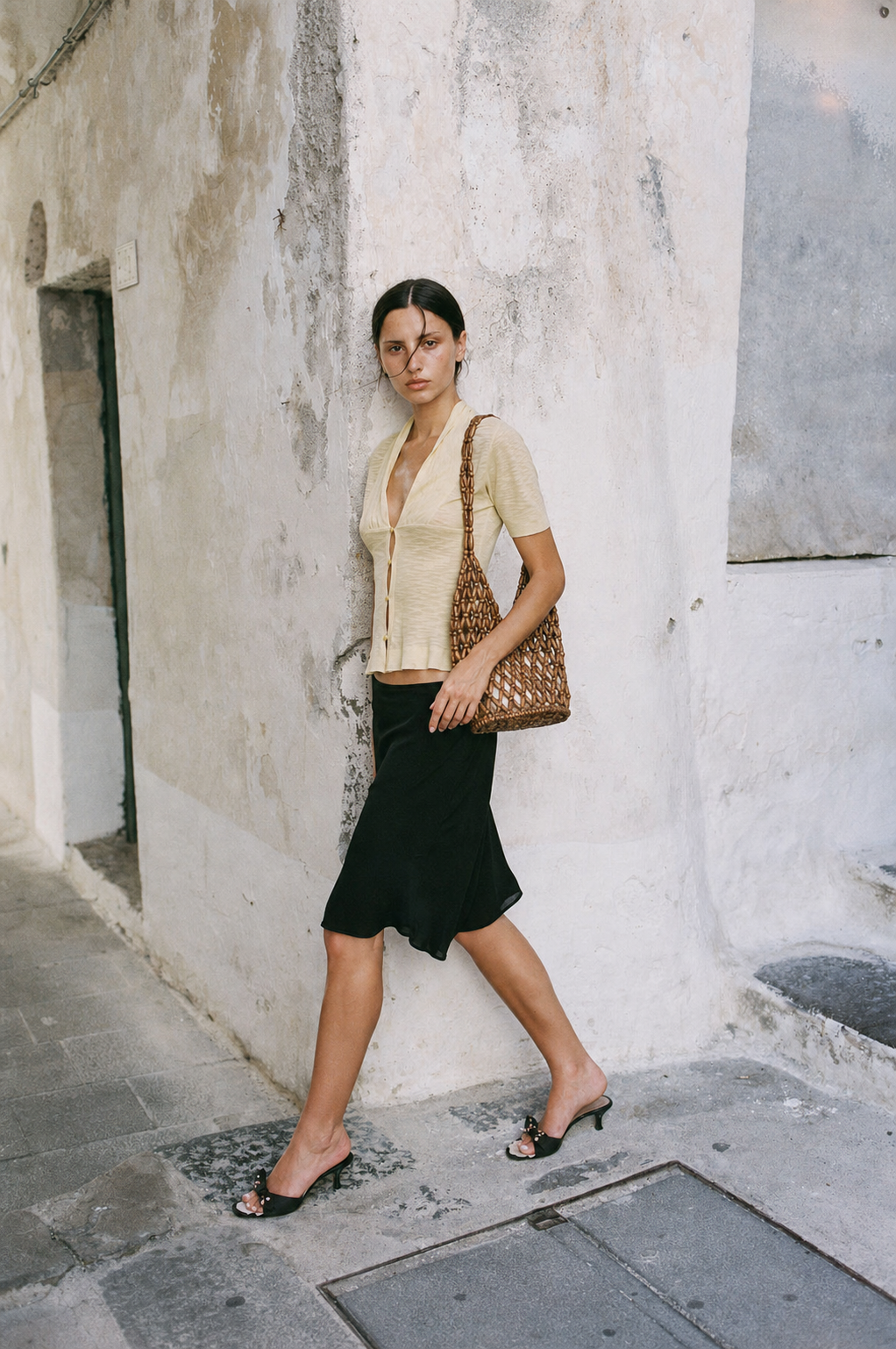 woman carrying tan wooden bead tote bag with summer outfit