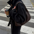woman carrying dark brown woven hobo shoulder bag street style