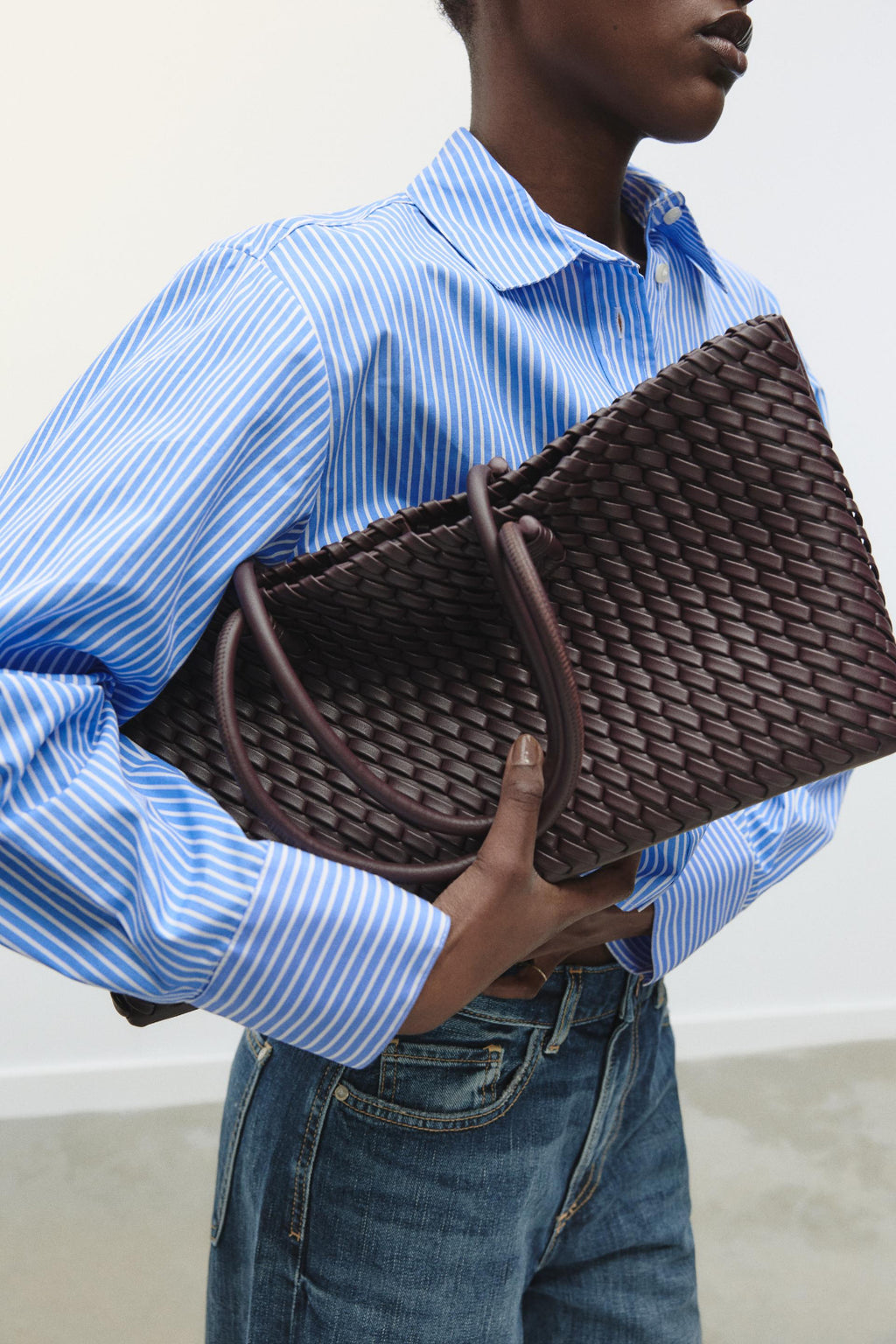 women carrying woven tote bag burgundy street style back view