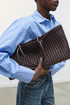 women carrying woven tote bag burgundy street style back view
