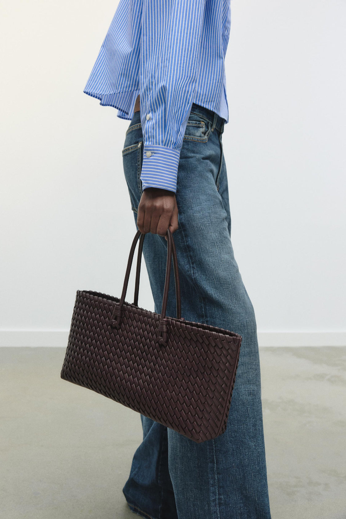 women carrying woven tote bag burgundy street style side